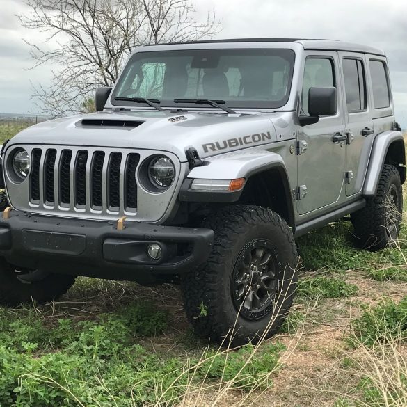 Three-quarter side view of a silver Jeep JL Wrangler Rubicon